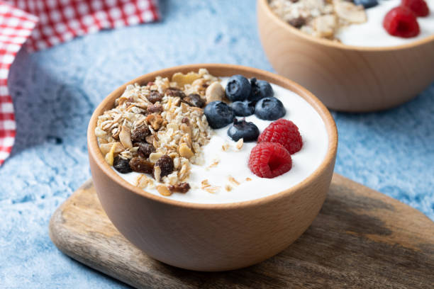 istock Yogurt with berries and muesli for breakfast in bowl on blue background 1481328580