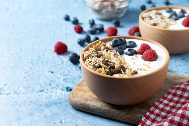 istock Yogurt with berries and muesli for breakfast in bowl on blue background 1481328599