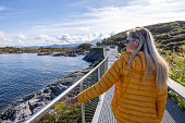 Young woman visiting Norway, she walks on an elevated pathway