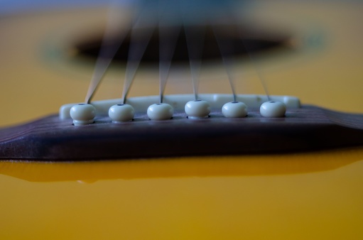 A close-up shot of a classic guitar, highlighting the strings and fretboard