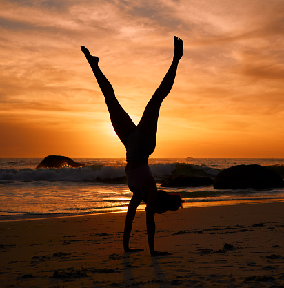 Yoga woman, silhouette or handstand on sunset beach, sea or ocean in workout or relax exercise training. Yogi, pilates or sand balance pose at sunrise for healthcare wellness fitness or strong body