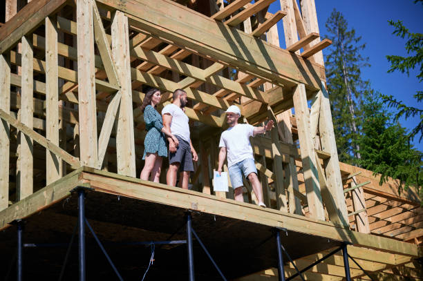 istock Man designer with plan showing the process of constructing wooden framed house. 1481333823