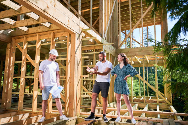 istock Man designer with plan showing the process of constructing wooden framed house. 1481333827