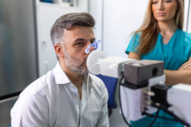 Adult man testing breathing function by spirometry having health problem. Diagnosis of respiratory function in pulmonary disease. Adult man testing breathing function by spirometry having health problem. Diagnosis of respiratory function in pulmonary disease. cardio pulmonary stock pictures, royalty-free photos & images