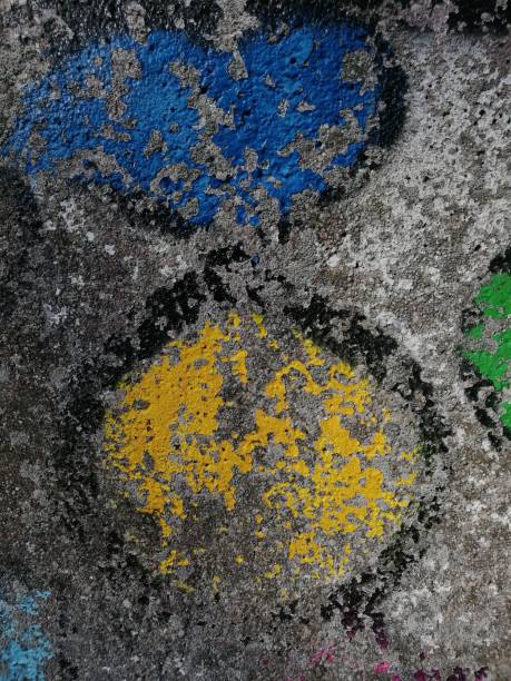 istock Old weathered graffiti mural featuring yellow and green lettering adorns a sidewalk 1481335325