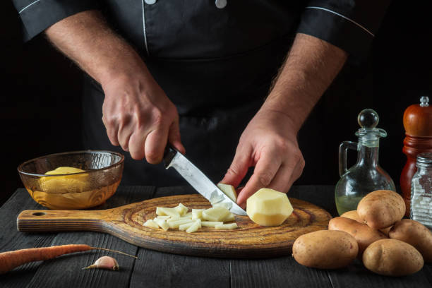 istock The chef cuts raw potatoes into pieces with a knife before preparing breakfast or dinner. Close-up of a cook hands while working in a restaurant kitchen. 1481336845
