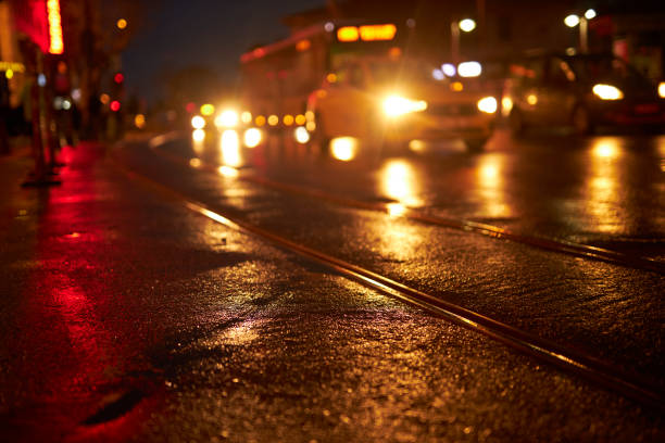 reflection of red traffic light and orange lights on a rainy city night