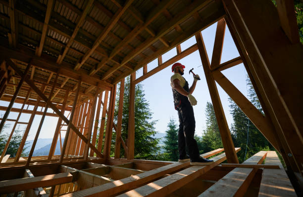 istock Carpenter hammering nail while constructing wooden frame two-story house near the forest. 1481338776