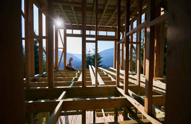istock Carpenter hammering nail while constructing wooden frame two-story house near the forest. 1481338777