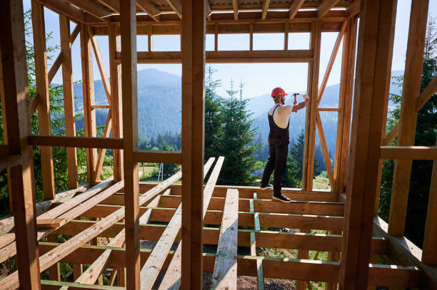 istock Carpenter hammering nail while constructing wooden frame two-story house near the forest. 1481338783
