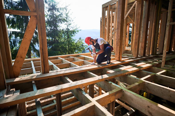 istock Carpenter hammering nail while constructing wooden frame two-story house near the forest. 1481338792