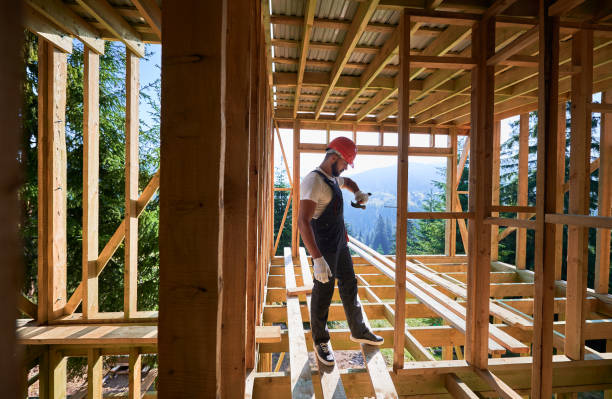 istock Carpenter hammering nail while constructing wooden frame two-story house near the forest. 1481338796