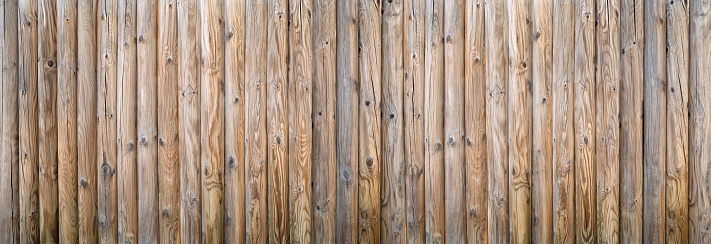 Privacy fence made of thick round woods with strong wood grain, detail as panorama