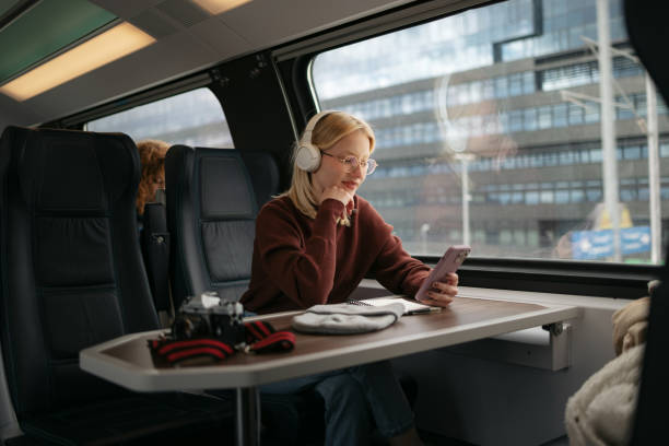 istock Smiling female tourist using smart phone while enjoying in music in a train. 1481340629
