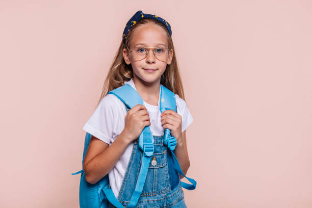 istock Cute blond school girl with backpack posing at studio 1481340650