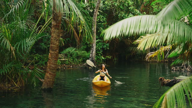 Woman kayaking in the  lagoon in jungles