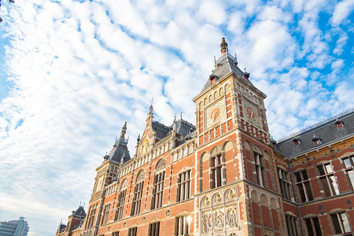 Amsterdam Central station building exterior with a blue sky in the background.