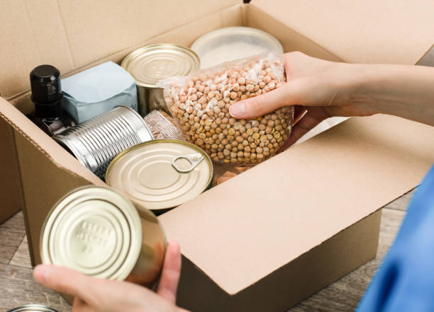 istock volunteer puts groceries in a cardboard box 1481343575