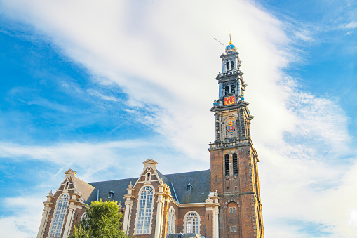 Amsterdam Westerkerk church tower during summer with a blue sky in the background.