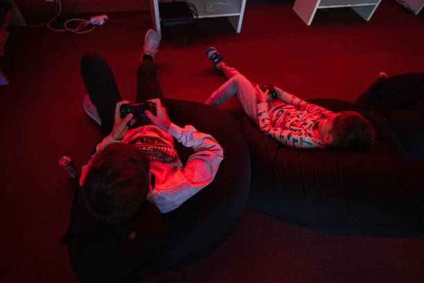 istock Two boys gamers play gamepad video game console in red gaming room. 1481345165