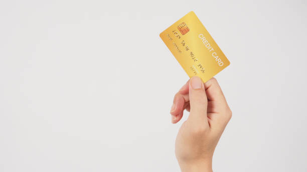 istock Hand is holding gold credit card isolated on white background. 1481345705