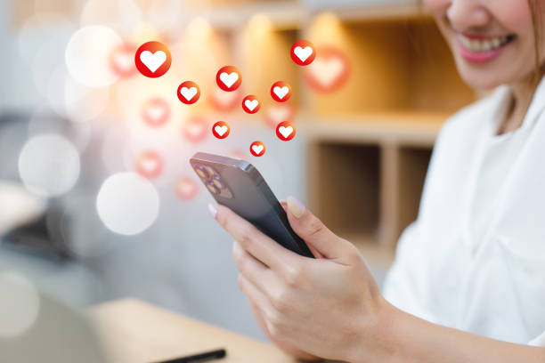 istock woman using smartphone with love button icons. 1481347307
