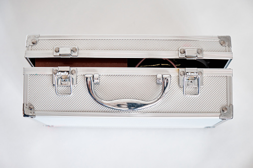 Weathered metal aluminum suitcase isolated on white background.