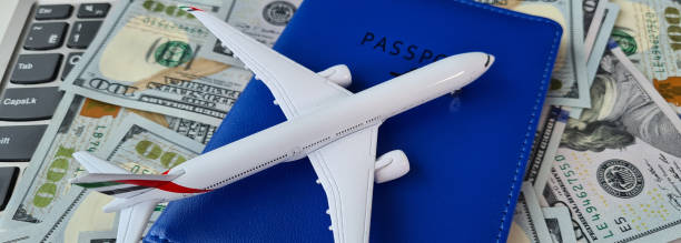 istock Airplane with passport and dollars on computer keyboard 1481348883