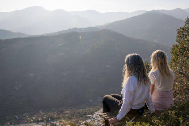 istock Senior female hikers relax at summit viewpoint above distant mountains 1481350110