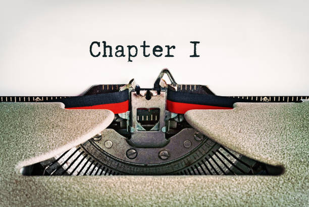 il capitolo 1, dice l'inizio della storia su una pagina in una macchina da scrivere retrò vecchio stile - typewriter typing beginnings blank foto e immagini stock