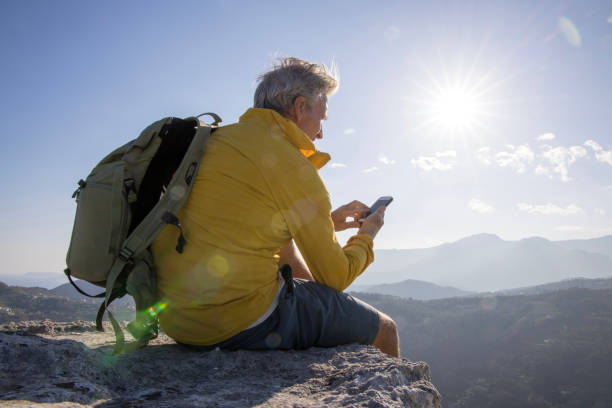 istock Senior man uses smart phone on at summit 1481351238
