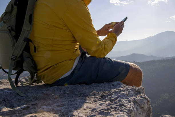 istock Senior man uses smart phone on at summit 1481351239