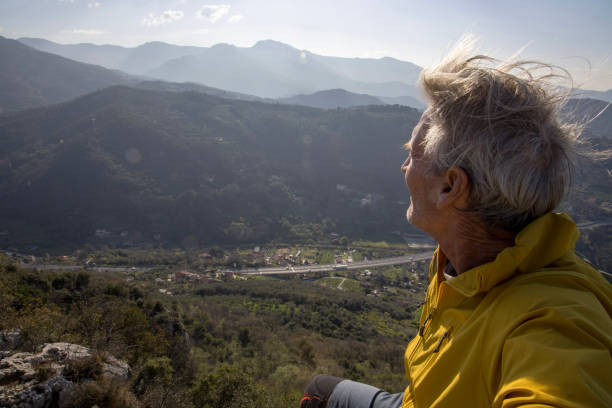 istock Senior hiker relaxes on summit and looks out 1481351571