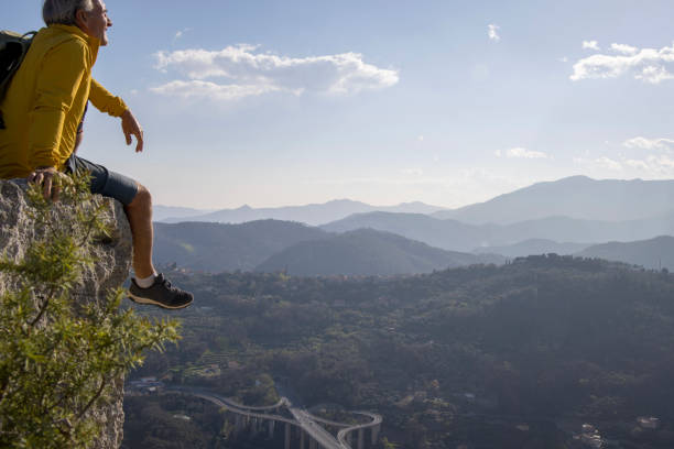 istock Senior hiker relaxes on summit and looks out 1481351868