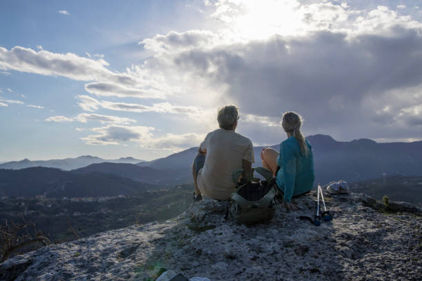 istock Senior couple hiker on summit viewpoint above distant mountains 1481353544
