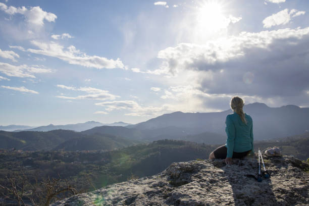istock Mature female hiker relaxes at summit viewpoint above distant mountains 1481354454
