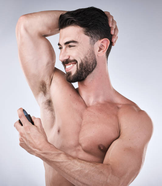istock Cosmetics, deodorant and man with smile, product and wellness on grey studio background. Perfume for arm pit, confident male and gentleman with happiness, fragrance and morning routine for grooming 1481354507