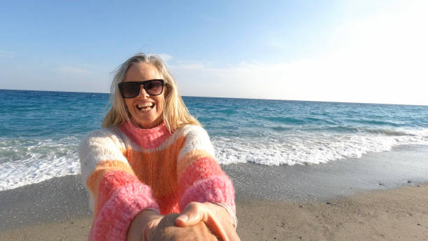 istock POV of woman pulling man onto beach 1481356039