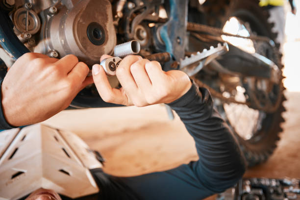 istock Hands, mechanic and engine gear repairs working on motor with tools for safety or mechanical parts. Hand of engineer fixing motorbike, transport or transmission on automobile or vehicle in workshop 1481357191