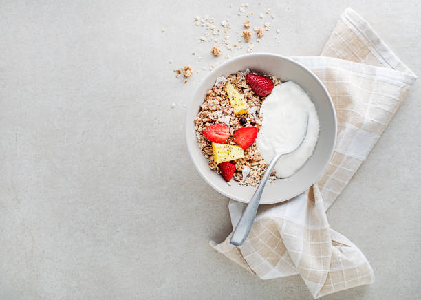 A plate of dry granola served with fresh fruit and yogurt. Oatmeal plate. Healthy food, diet. Top view.