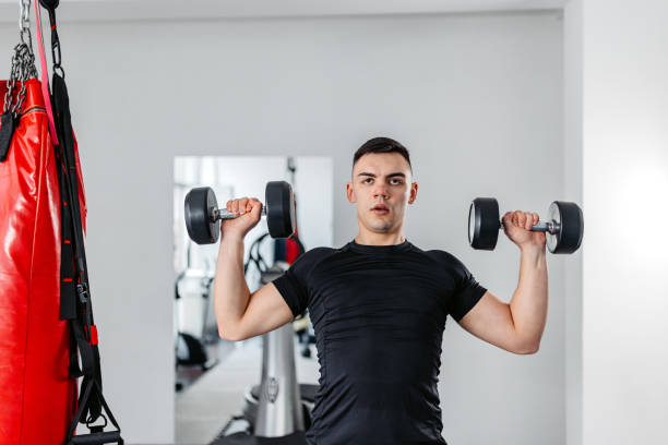 istock Young Man Training With Dumbbells At The Gym 1481357413