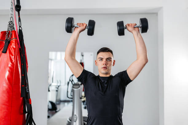 istock Young Man Training With Dumbbells At The Gym 1481357429