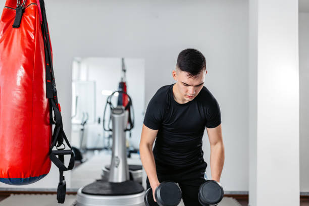 istock Young Man Training With Dumbbells At The Gym 1481358404