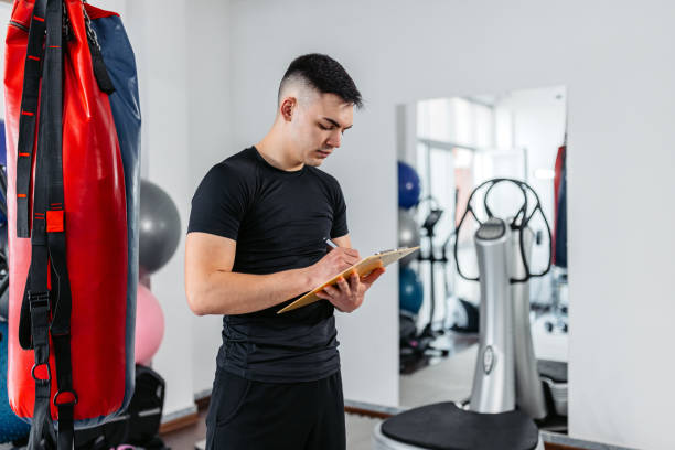 istock Young Man Writing Down His Gym Progress In The Gym 1481358613