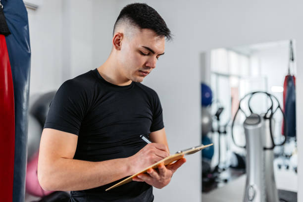 istock Young Man Writing Down His Gym Progress In The Gym 1481358657