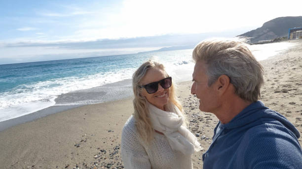 istock Senior couple walk along beach at seaside 1481358863