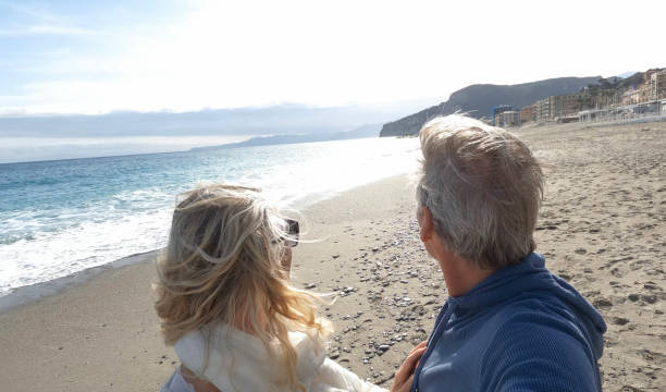 istock Senior couple walk along beach at seaside 1481358974