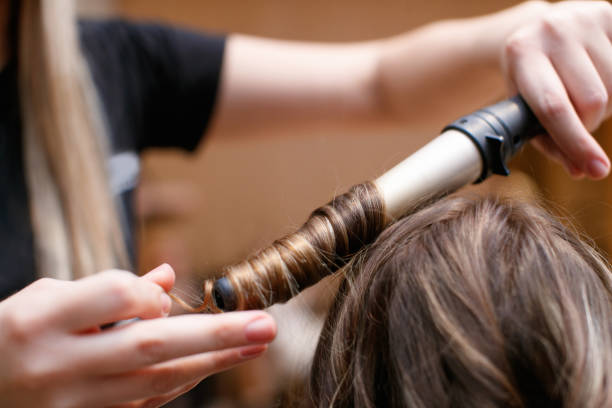 istock Making curls on brown hair with hot curler 1481363348