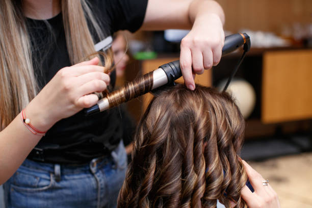 istock Using hot curler and making curls in hair salon 1481363375
