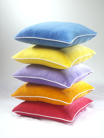 Colorful cushion, pillow tower on white